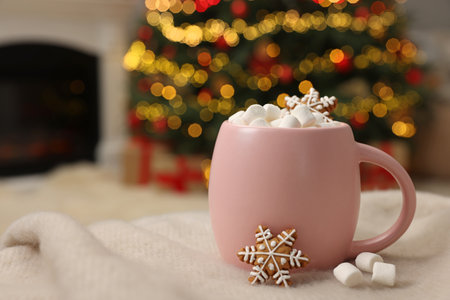 Christmas cocoa with marshmallows in pink cup on soft blanket indoors, closeup. Space for textの写真素材