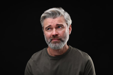 Personality concept. Portrait of emotional man on black backgroundの写真素材