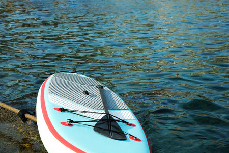 One SUP board with paddle on sea shore