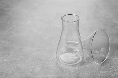 Flask and filter funnel on gray textured table, space for text. laboratory glasswareの写真素材