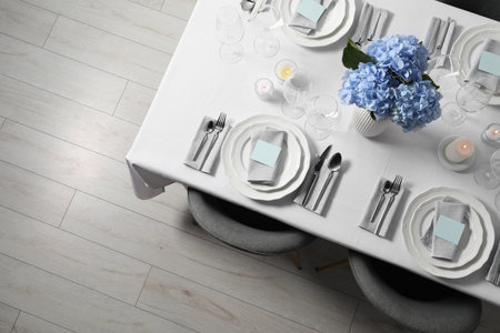 Beautiful table setting with blank cards and floral decor, top viewの写真素材