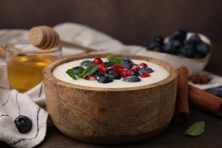 Bowl of delicious semolina pudding with blueberries, pomegranate and mint on table, closeupの写真素材
