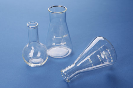 Different flasks on blue background. laboratory glassware