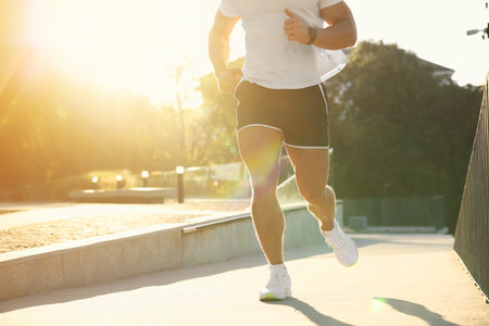 Man running outdoors on sunny day, closeup. Space for textの写真素材