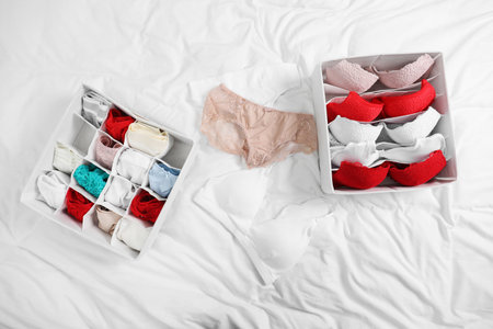 Organizers with stylish women's underwear on bed, flat layの写真素材