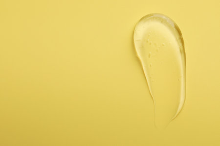 Smear of clear cosmetic gel on yellow background, top view. Space for textの写真素材