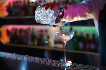 Bartender making fresh alcoholic cocktail at counter in bar, closeupの写真素材