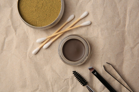 Flat lay composition with eyebrow henna and tools on crumpled paperの写真素材