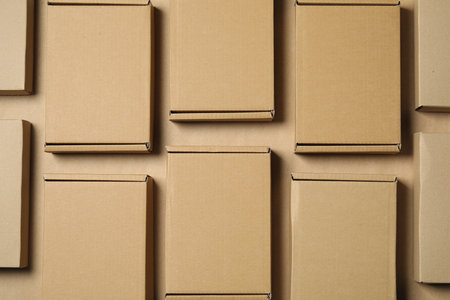 Many closed cardboard boxes on light brown background, flat layの写真素材