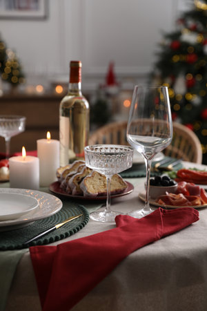 Christmas table setting with burning candles, appetizers and dishware indoorsの写真素材