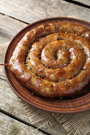 Plate with tasty homemade sausages on wooden table, closeupの写真素材