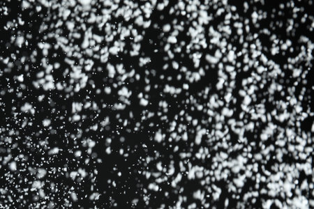 White snow falling down on black backgroundの写真素材