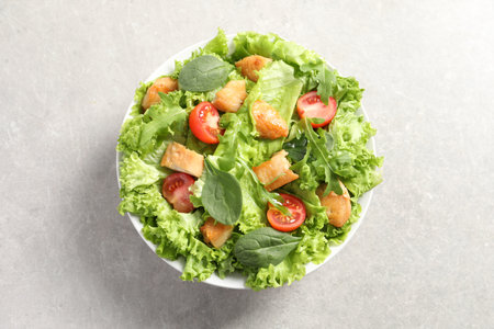 Delicious salad with chicken, cherry tomato and spinach on light gray table, top viewの写真素材