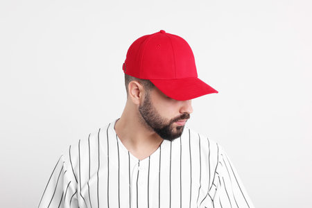 Man in stylish red baseball cap on white backgroundの写真素材
