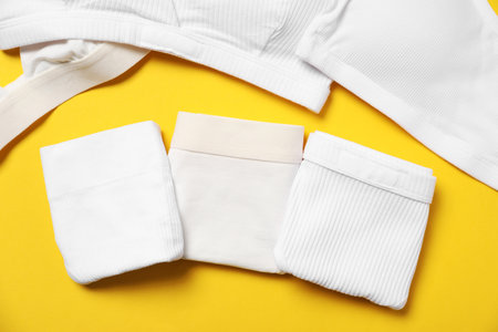 Stylish folded women's underwear on yellow background, flat layの写真素材