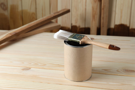 Can and brush with wood stain on wooden surface. Space for textの写真素材