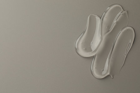 Sample of clear cosmetic gel on gray background, top view. Space for textの写真素材