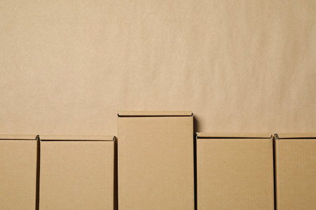 Many closed cardboard boxes on light brown background, flat lay. Space for textの写真素材