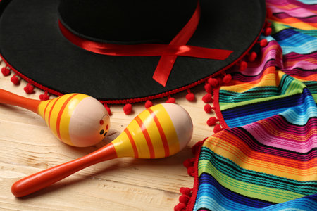 Mexican sombrero hat, maracas and colorful poncho on wooden backgroundの写真素材