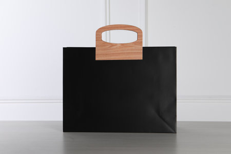 Black paper bag on white wooden tableの写真素材