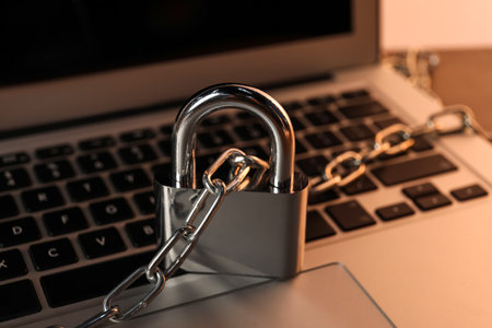 Cyber security. Laptop with padlock and chain on table, closeupの写真素材