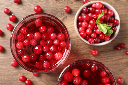 Tasty cranberry juice in glasses and fresh berries on wooden table, flat layの写真素材