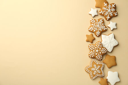 Tasty Christmas cookies with icing on beige background, flat lay. Space for textの写真素材