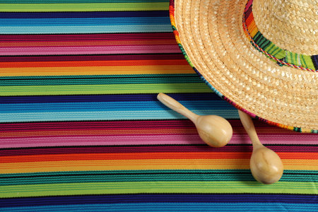 Mexican sombrero hat and maracas on color table, top view. Space for textの写真素材