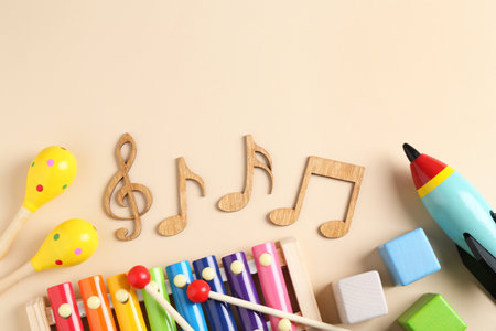 Baby song concept. Wooden notes, kids xylophone and toys on beige background, flat lay. Space for textの写真素材