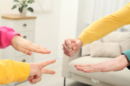 People playing rock, paper and scissors indoors, closeupの写真素材