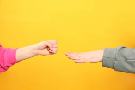 People playing rock, paper and scissors on orange background, closeup