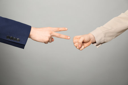 People playing rock, paper and scissors on gray background, closeupの写真素材