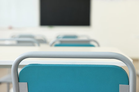 Empty school classroom with desks and chairsの写真素材