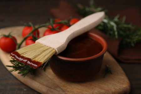 Marinade in bowl and basting brush on wooden table, closeupの写真素材