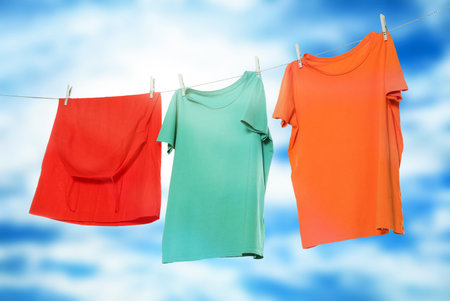Different clothes drying on washing line against blue skyの写真素材