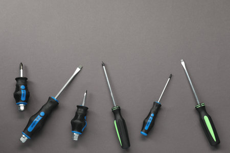 Set of screwdrivers on gray background, flat lay. Space for textの写真素材