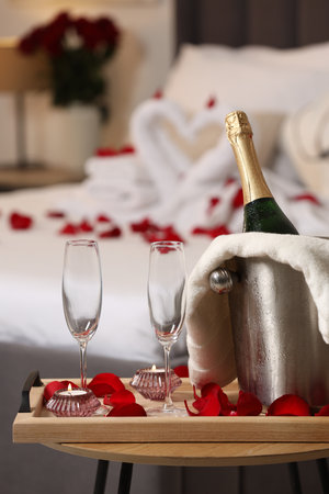 Honeymoon. Sparkling wine and glasses on wooden table in roomの写真素材