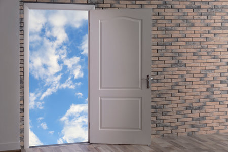 Beautiful blue sky with fluffy clouds visible through open doorの写真素材