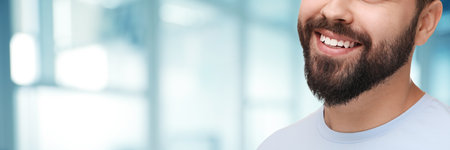 Man with clean teeth smiling on blurred background, closeup. Banner design with space for textの写真素材
