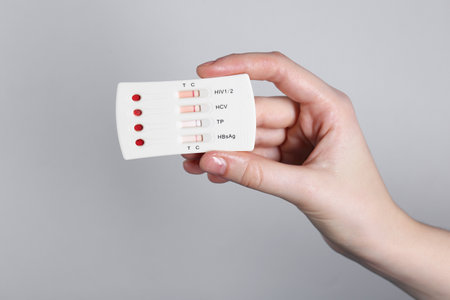 Woman holding disposable multi-infection express test on light gray background, closeupの写真素材