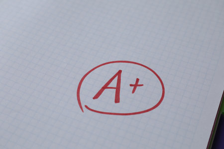 School grade. Red letter A with plus symbol on notebook paper, closeupの写真素材