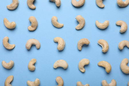 Many tasty cashew nuts on light blue background, top viewの写真素材