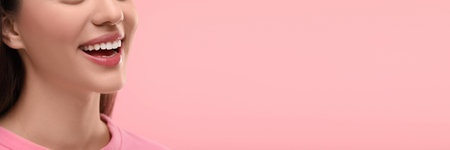 Woman with clean teeth smiling on pink background, closeup. Banner design with space for textの写真素材