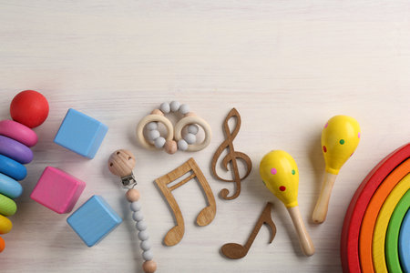 Baby song concept. Wooden notes, kids maracas and toys on table, flat lay. Space for textの写真素材