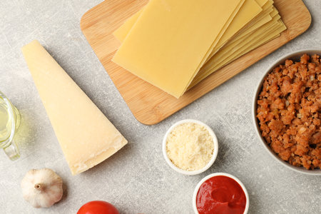 Flat lay composition with products for cooking lasagna on gray textured tableの写真素材