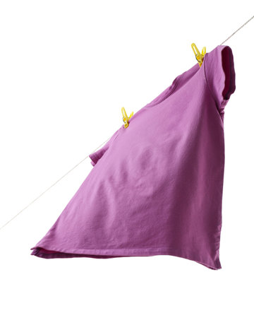 One violet t-shirt drying on washing line isolated on whiteの写真素材