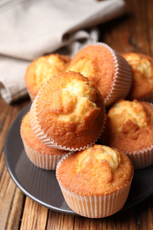 Delicious sweet muffins on wooden table, closeup