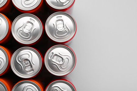 Energy drink in cans on gray background, top view. Space for textの写真素材