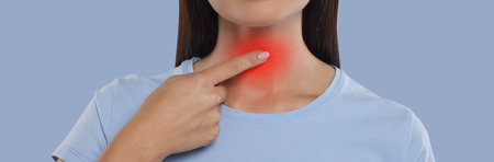 Endocrine system. Woman doing thyroid self examination on color background, closeup. Banner designの写真素材