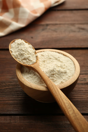 Baking powder in bowl and spoon on wooden table, closeupの写真素材